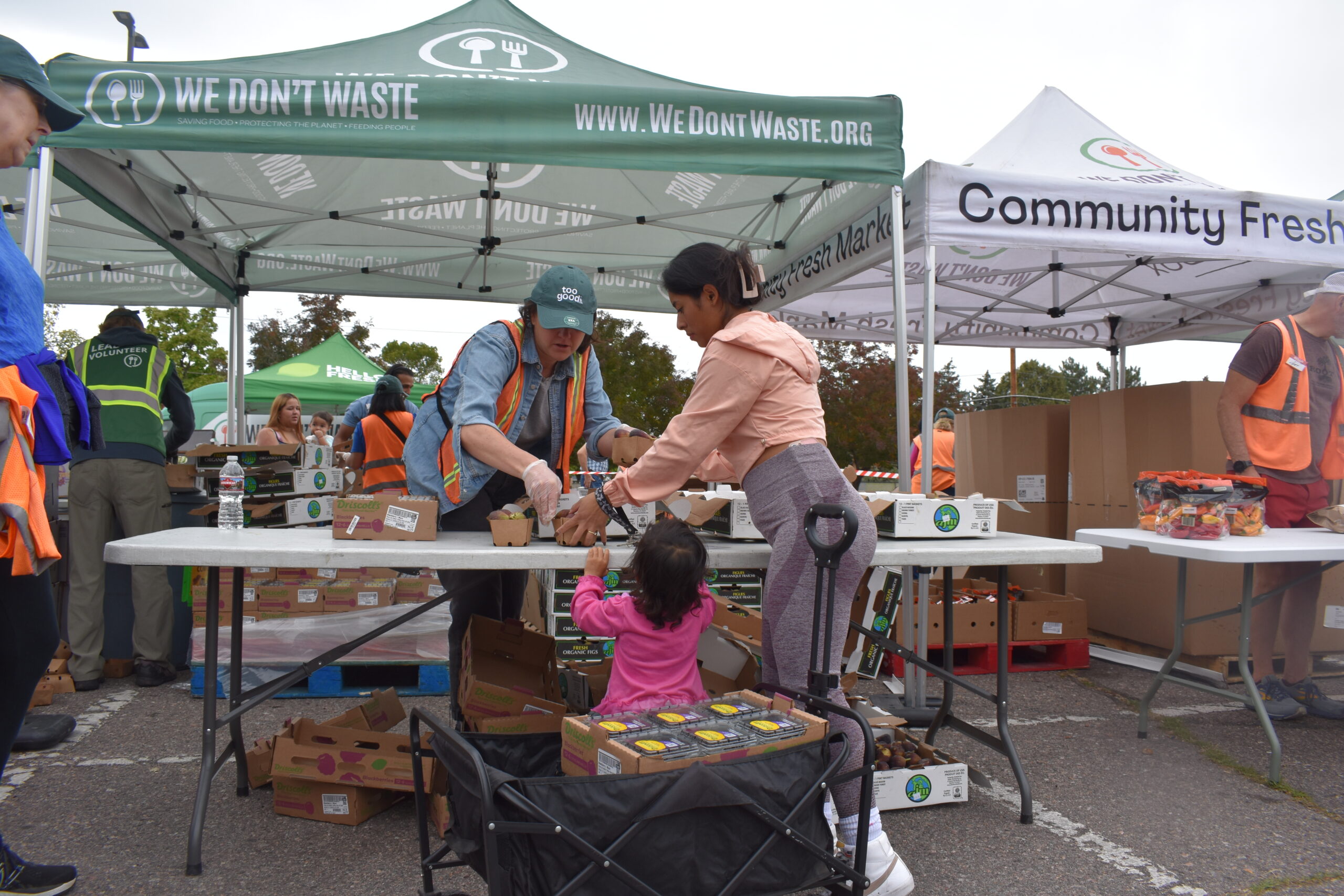 Mobile Food Market participant takes food handed to her by volunteer.