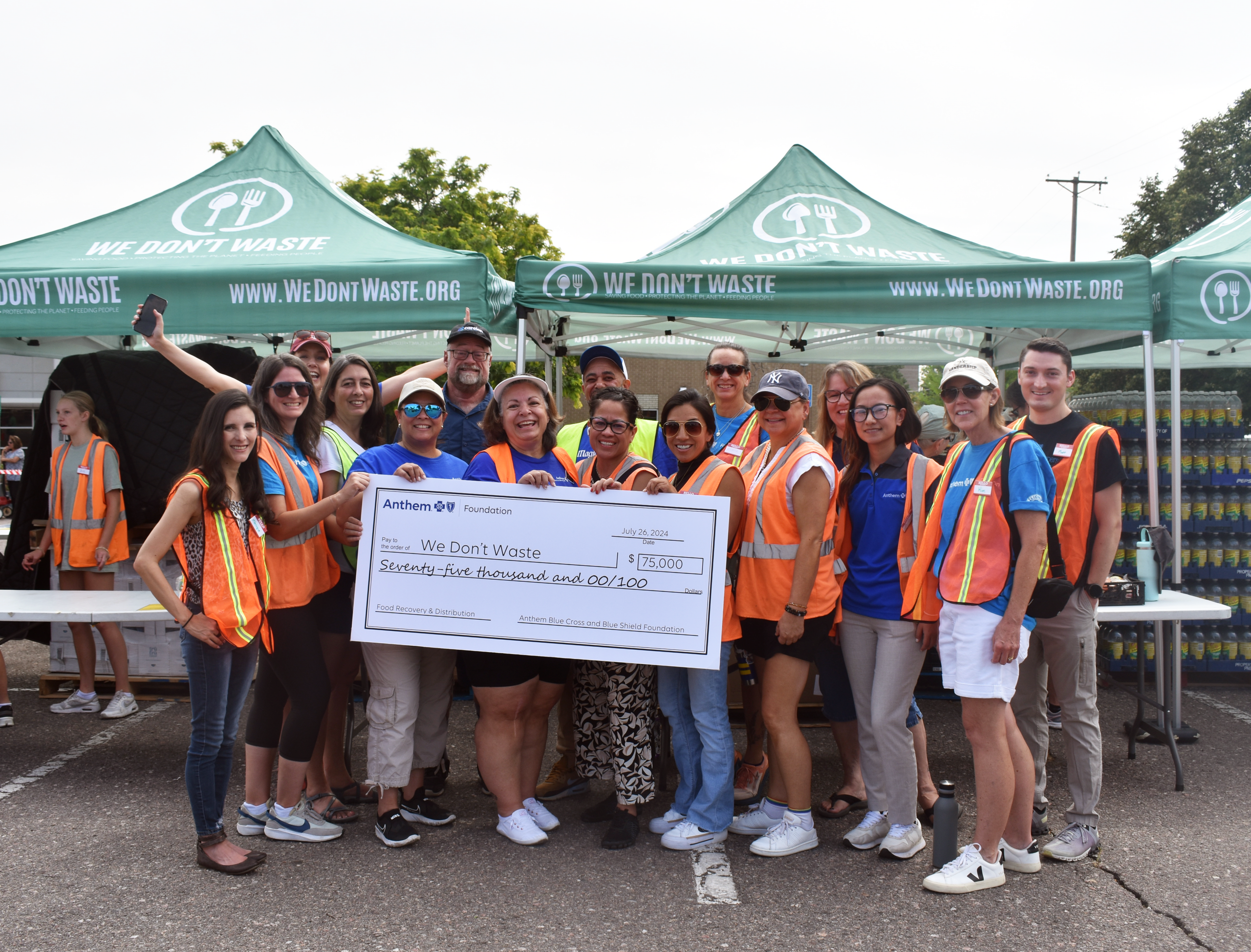 Anthem team presenting a check to We Don't Waste at a Mobile Food Market.