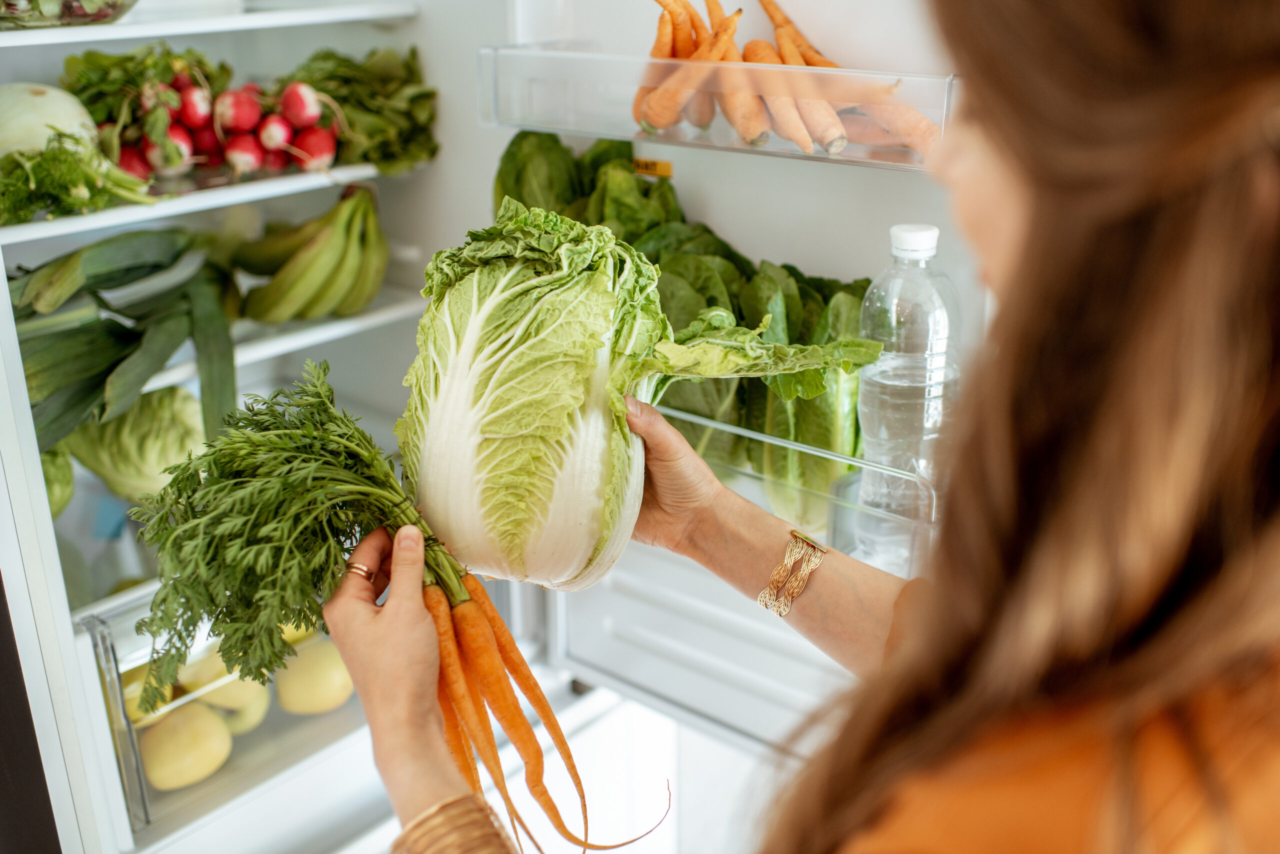 Woman taking fresh vegetables from the refrigerator